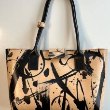The Abstract Art Tote was created by brush-painting black leather dye onto a whole hide of natural vegetable-tanned leather  then thoughtfully cut out. Hand-stitched using one piece of leather. The black handles are dyed and hand-sewn. Features a denim lining  a magnet tab closure and brass feet.