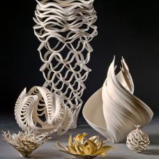 Group of  twisting porcelain  forms that have been carved. Some are accented with gold gilding. 