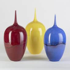 three vases with skinny necks in yellow, blue, and red