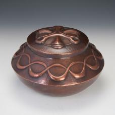 This hand raised copper vessel has features a chased lid and a rich brown patina.