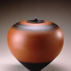 Thrown brown terracotta pot with black accents and small lid.