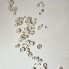 Wall with thin porcelain circles. Gold luster applied on some.