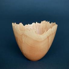 Gentle but spiky burl points dress the rim of this small vase. Color changes follow the natural rim and the burled sides shimmer. All adds to a reaching quality. The shape is a pleasure to hold.