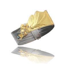 This bracelet has a gold repousse dragonfly on the front with a fused textural environment that has diamonds and a blue sapphire. The hinged cuff is patinated chased silver that has a diamond pressure fit clasp with 2 safeties clips.