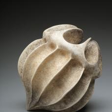 Porcelain form resembling a seed pod with rough grimey exterior.