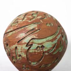 round vase with swirls of brown and green and inscription