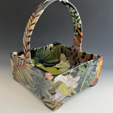 Basket made with a combination of hand-building and wheel-throwing techniques with painterly glaze and under glaze decoration of leaves and flowers on a dark background. 