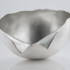 I took a flat sheet of silver and hammered it up into a three dimensional form using traditional silversmithing techniques. Sometimes during this process the metal begin to tear. I incorporated those tears into the form rather than cutting them out or repairing them.