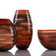 The INCISION SERIES of bottles + vases are created using a “stuffed cup” technique. A cup is blown  cooled  cut  brought back up to temperature and reformed into each shape we offer. Offered in translucent monochromatic color ways to emphasize the unique torn texture.