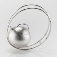 A fully functional sterling silver teapot. The piece rocks back and forth on the elliptical handles when put into motion. Techniques used in make this piece include hammering (raising  planishing  bouging)  soldering  filing  sanding  and riveting. Teflon and Delrin were to used as heat syncs.