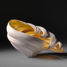 Porcelain that has been carved. Interior is gold gilded.