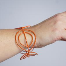 cuff bracelet with orange wire shapes with a lot of negative space